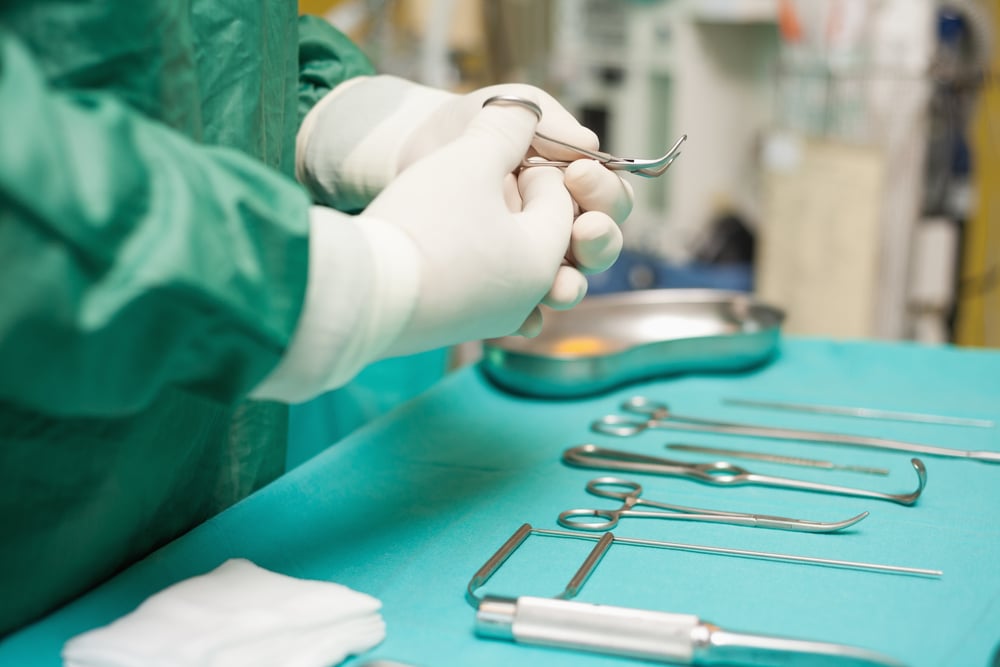 Surgeon choosing a surgical instrument in an operating room Surgeon choosing a surgical instrument in an operating room